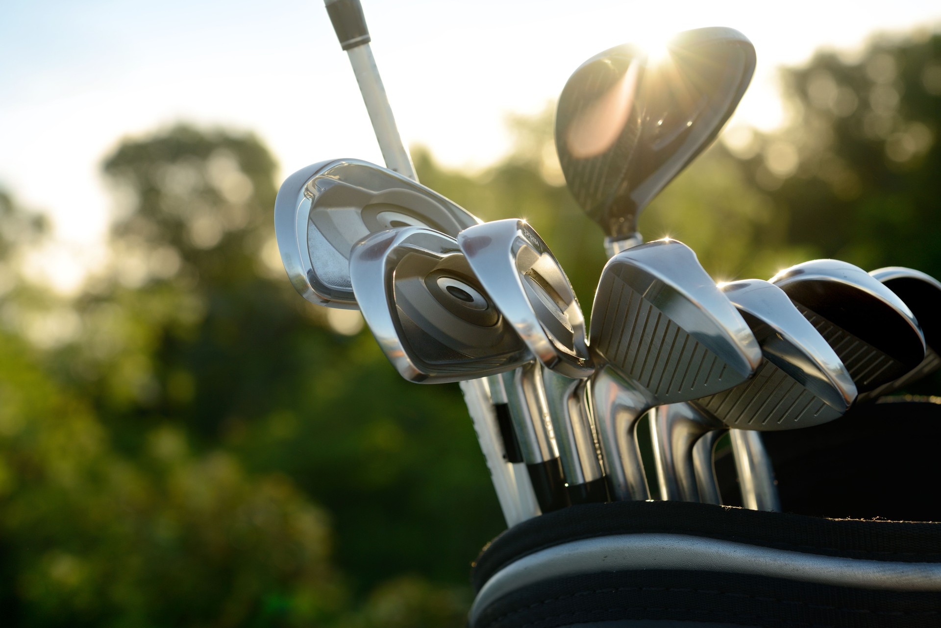 Silver golf clubs reflecting sun light